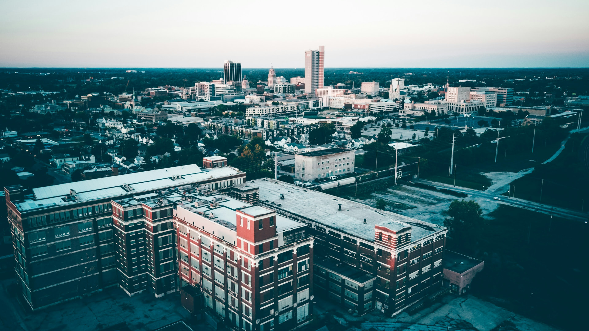 Aerial view of the Fort Wayne cityscape at dawn, the Church gathered across our city